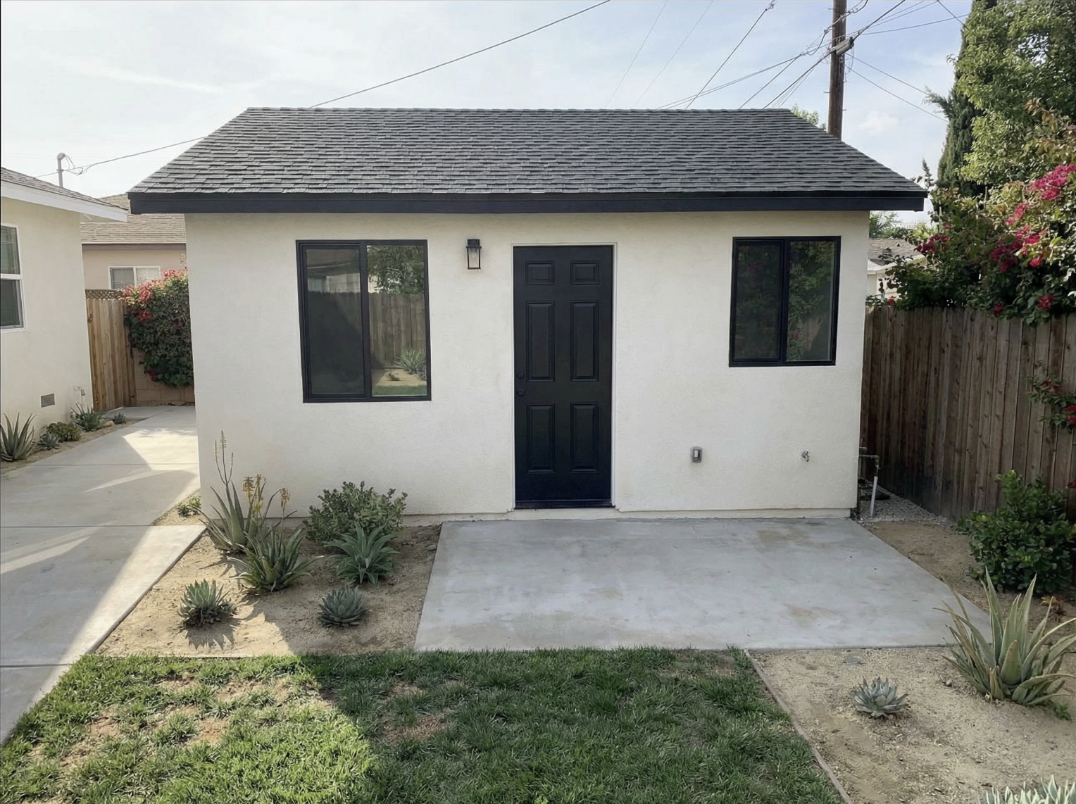 Completed ADU garage conversion with white stucco exterior and black windows — YBL Design & Build, Los Angeles
