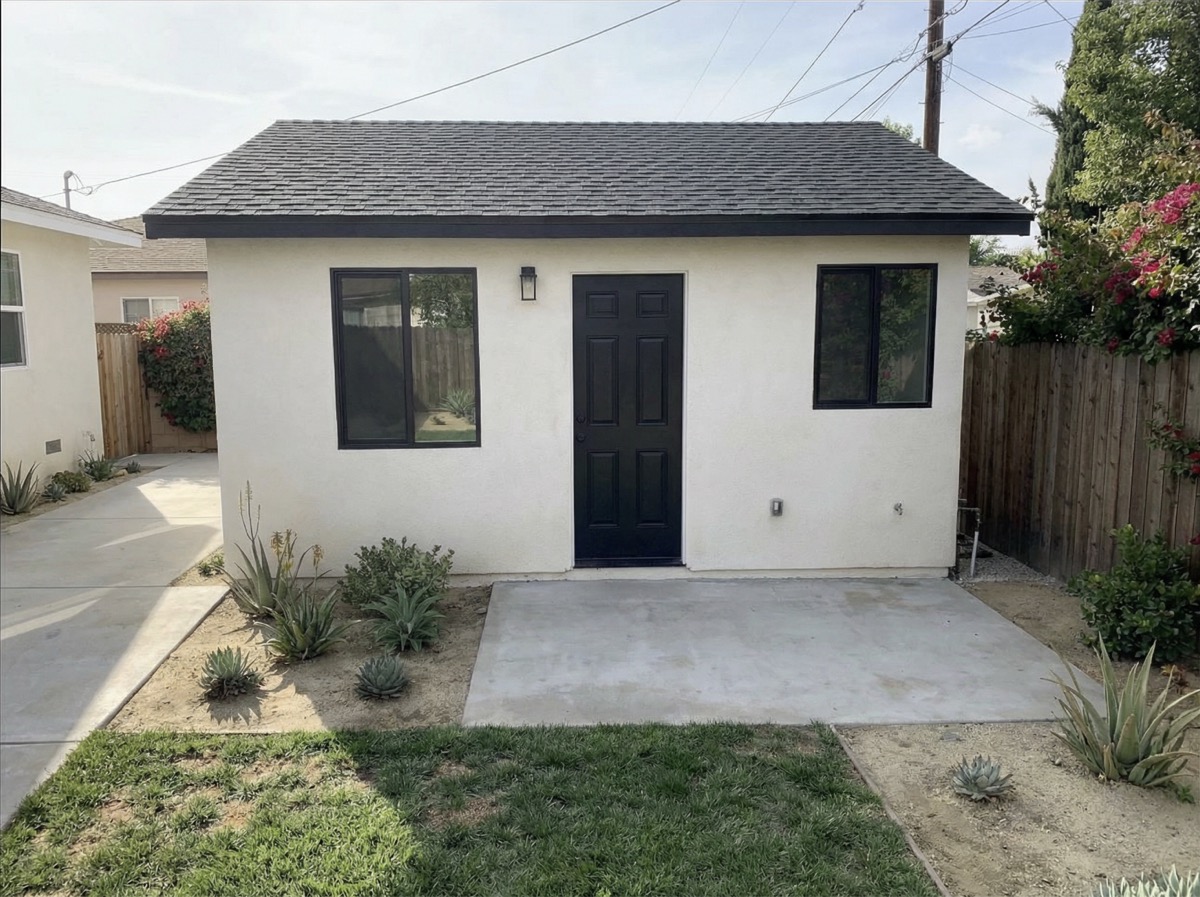 Completed garage conversion ADU with white stucco exterior and black-framed windows in Los Angeles — YBL Design & Build